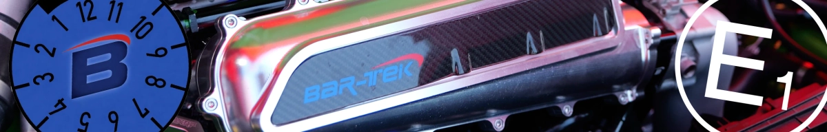 Nahaufnahme einer BAR-TEK Carbon-Motorabdeckung im Motorraum, kombiniert mit blauem B-Logo und E1-Prüfzeichen