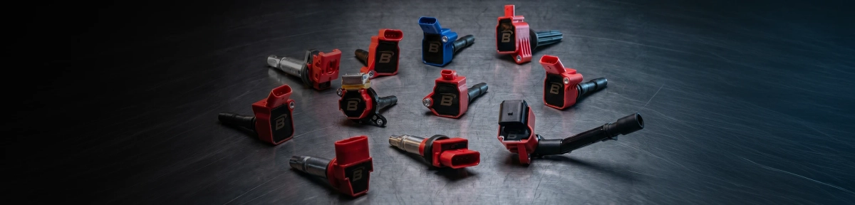 Several red and blue ignition coils arranged as car spare parts on a dark workbench